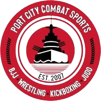 A red and black logo of port city combat sports.