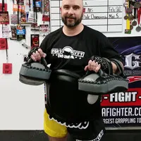 A man holding two pairs of boxing gloves.