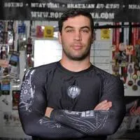 A man with his arms crossed in front of a wall.