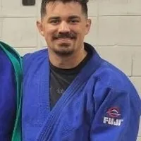 A man in blue and black uniform standing next to another person.