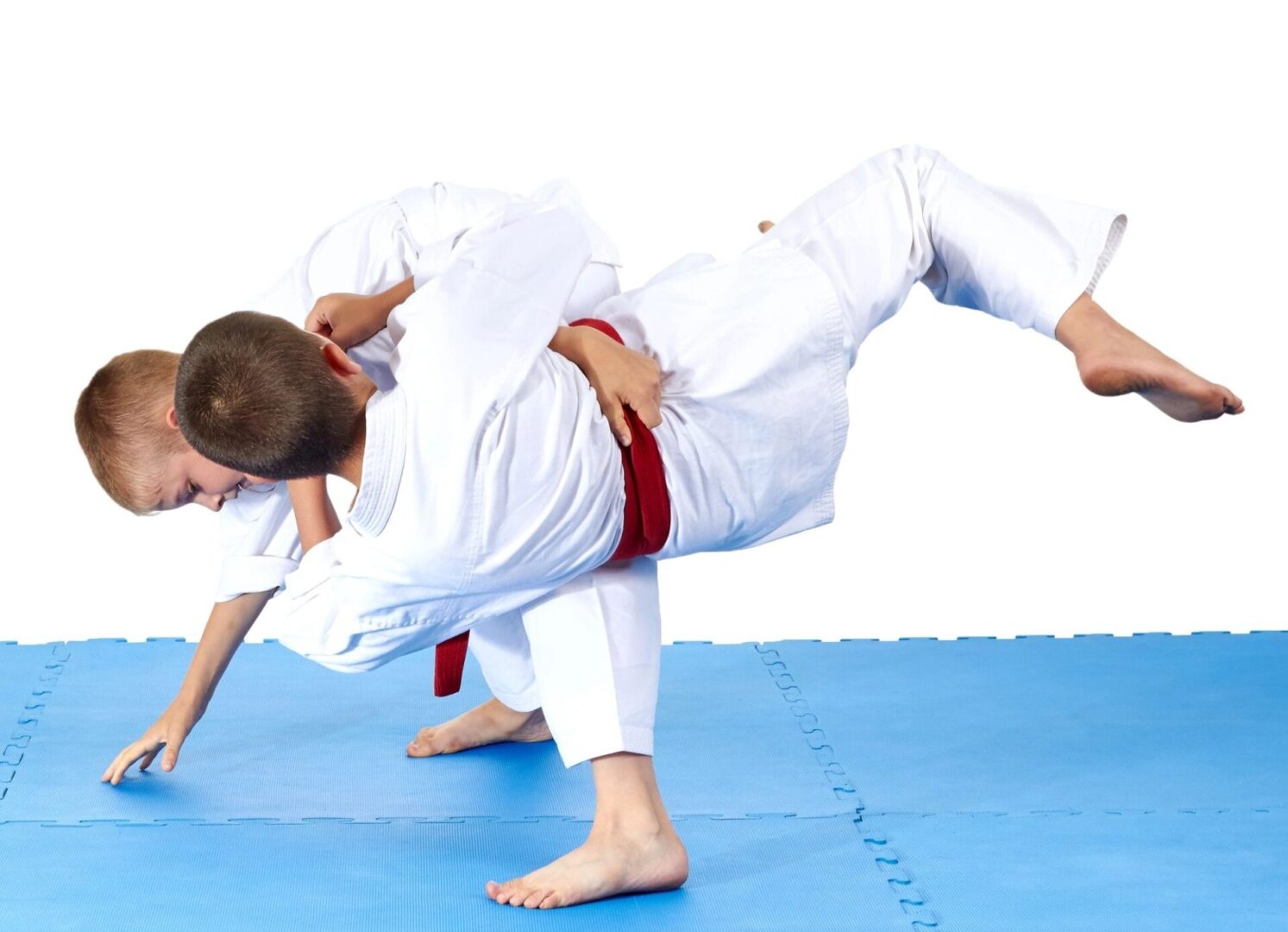 Two men in white and red judo uniforms are practicing a move.