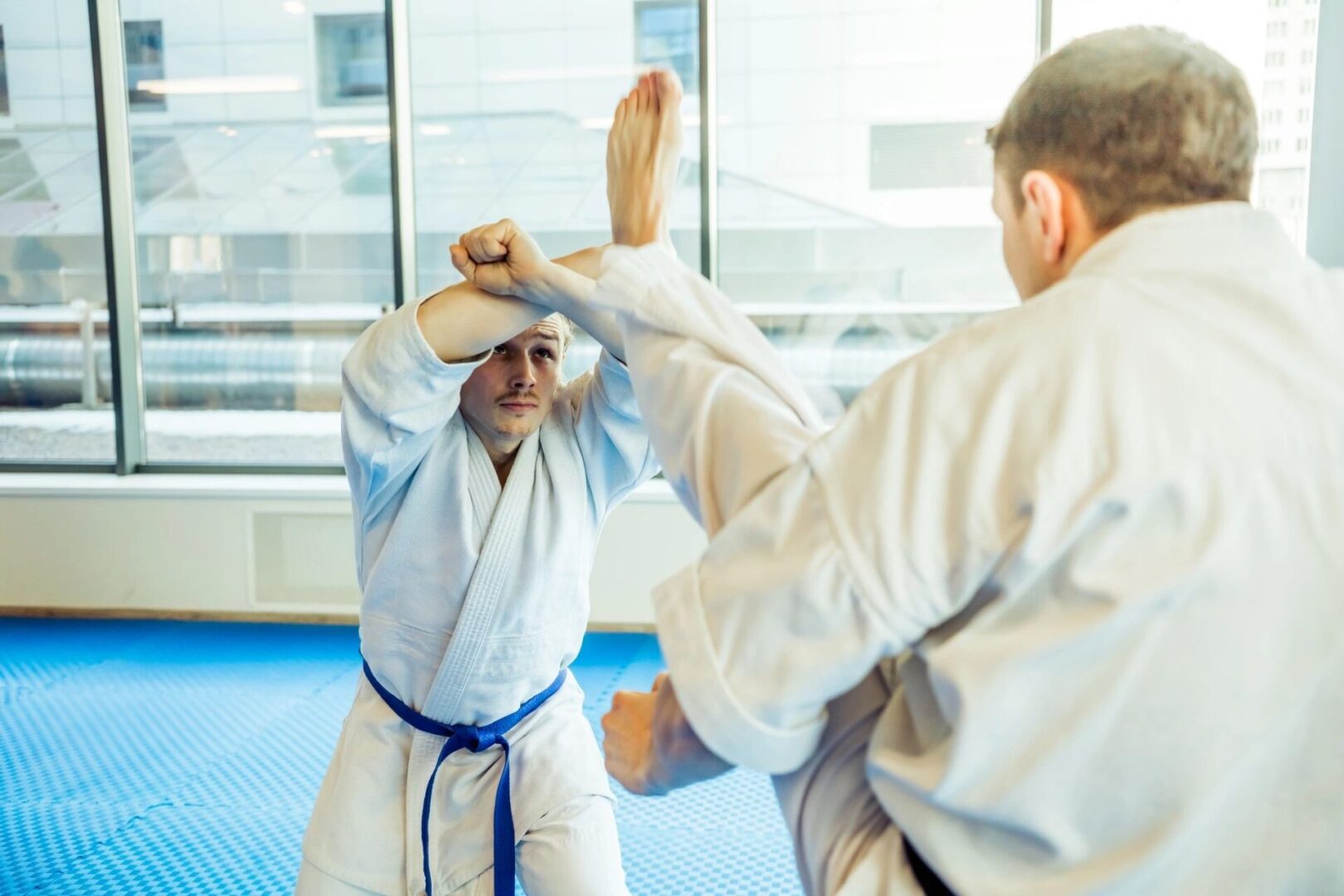 Two men in white and blue uniforms practicing martial arts.