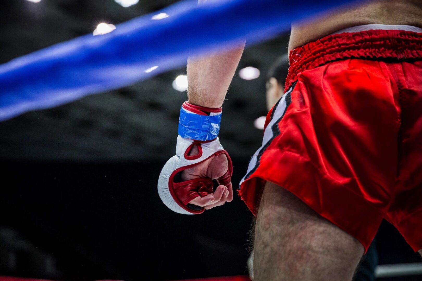 A close up of the arm and hand of a person in a boxing ring.