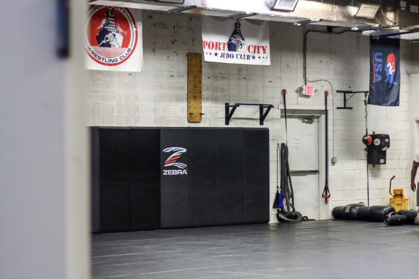 A gym with a wall and a black mat